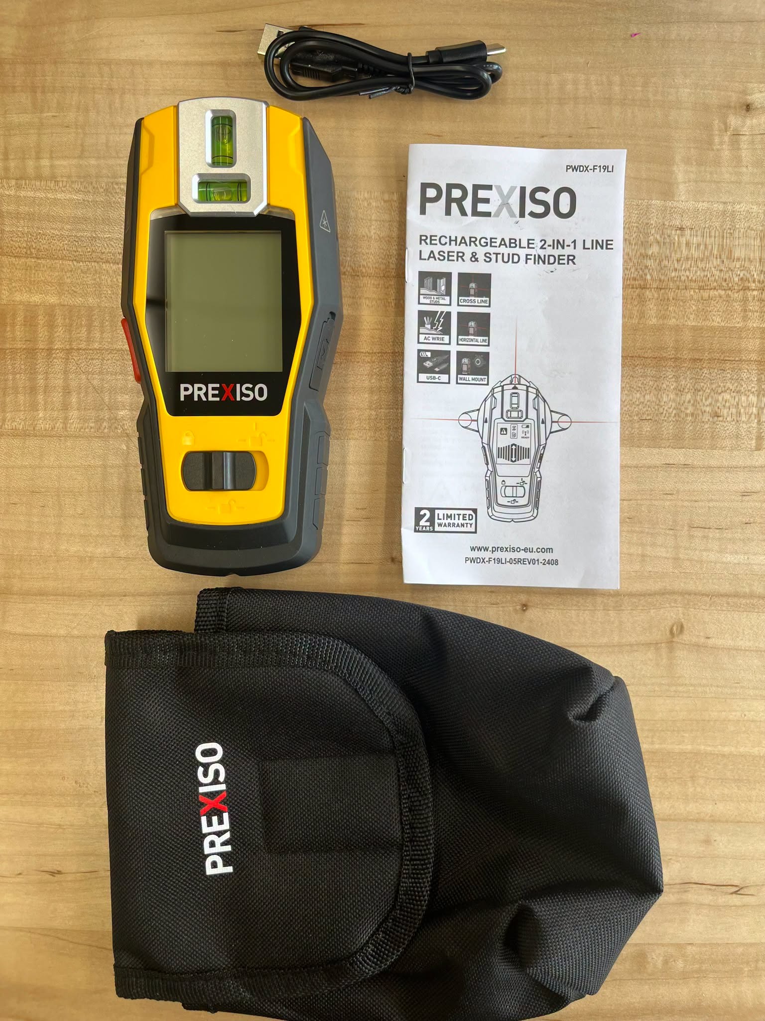 A Prexiso rechargeable 2-in-1 laser and stud finder with its instruction manual, a black USB-C charging cable, and a black protective carry pouch.<br />
