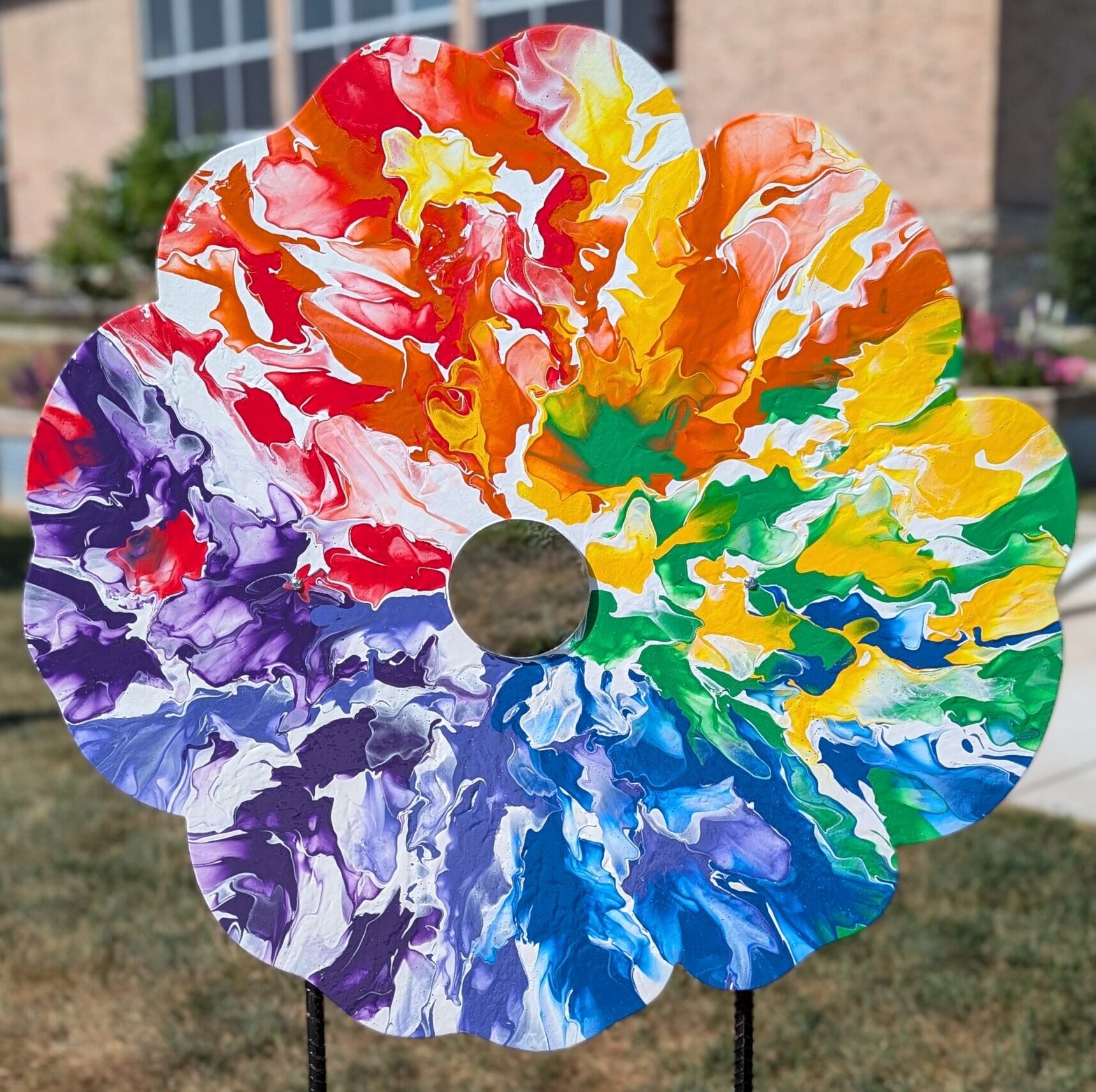 Poppy cut-out with a rainbow paint pour design with a mirror middle