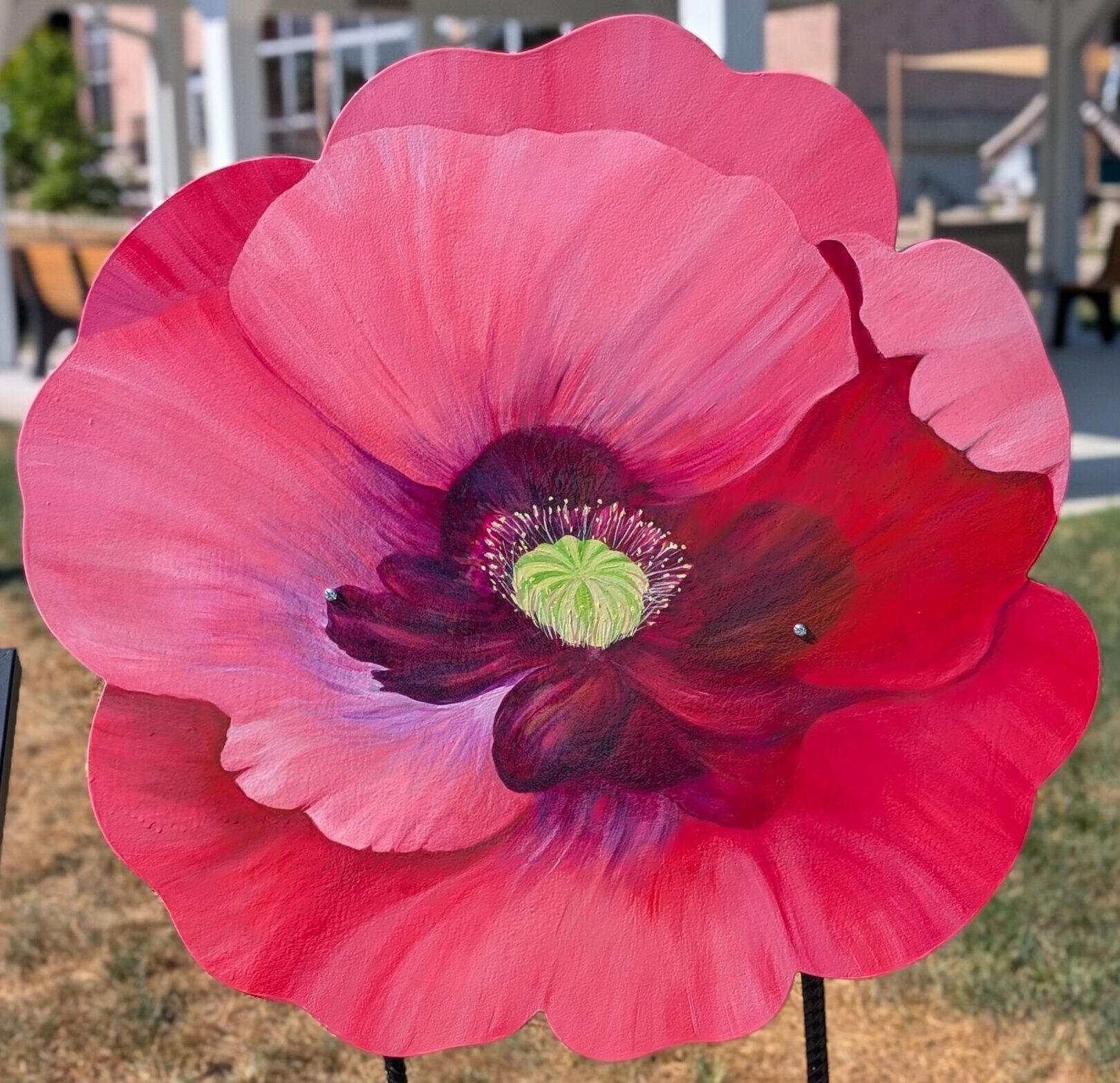 Poppy cut-out that is painted to look like a hyper realistic read poppy