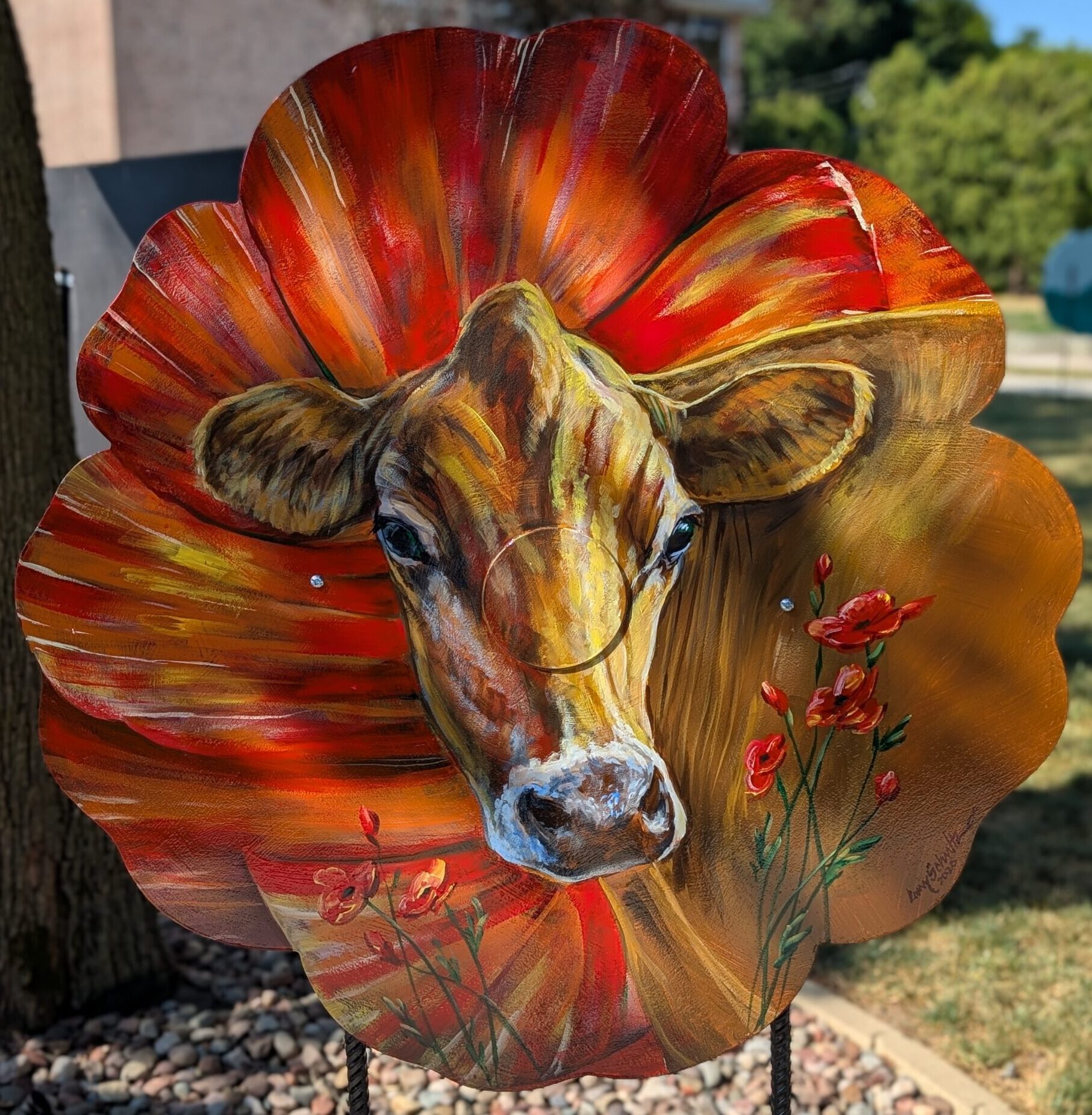 poppy cut-out painted with a realistic jersecy cow in front of a poppy