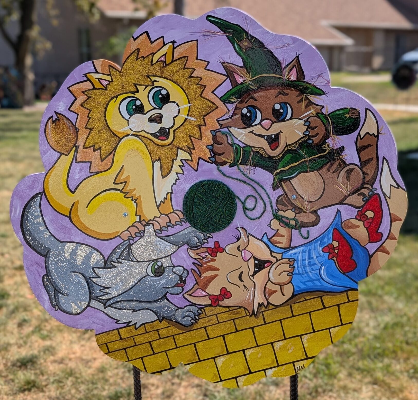 poppy cut-out painted with cartoon kittens as each of the characters of The Wizard of Oz