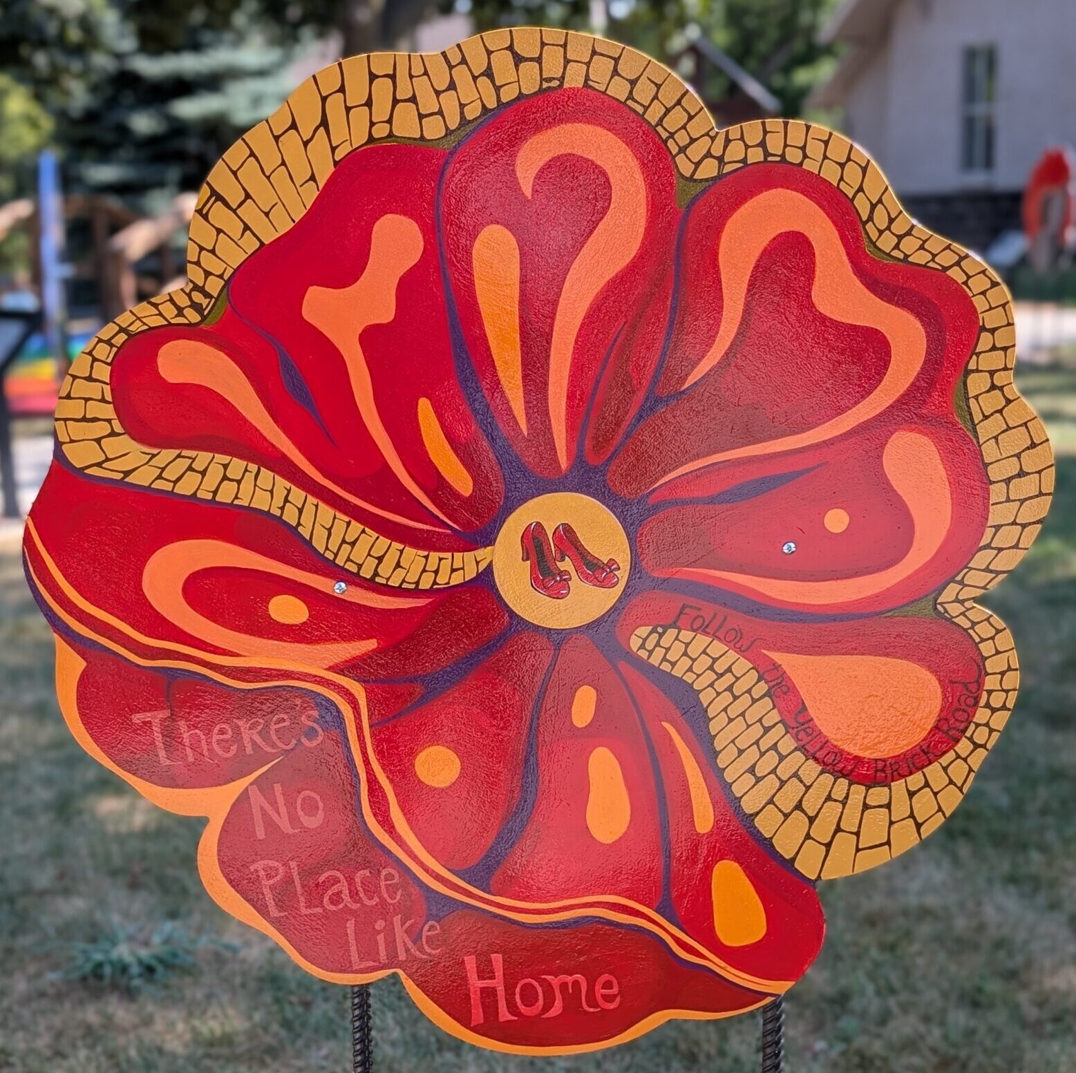Poppy cut-out painted with red and orange sections and parts painted as the yellow brick road