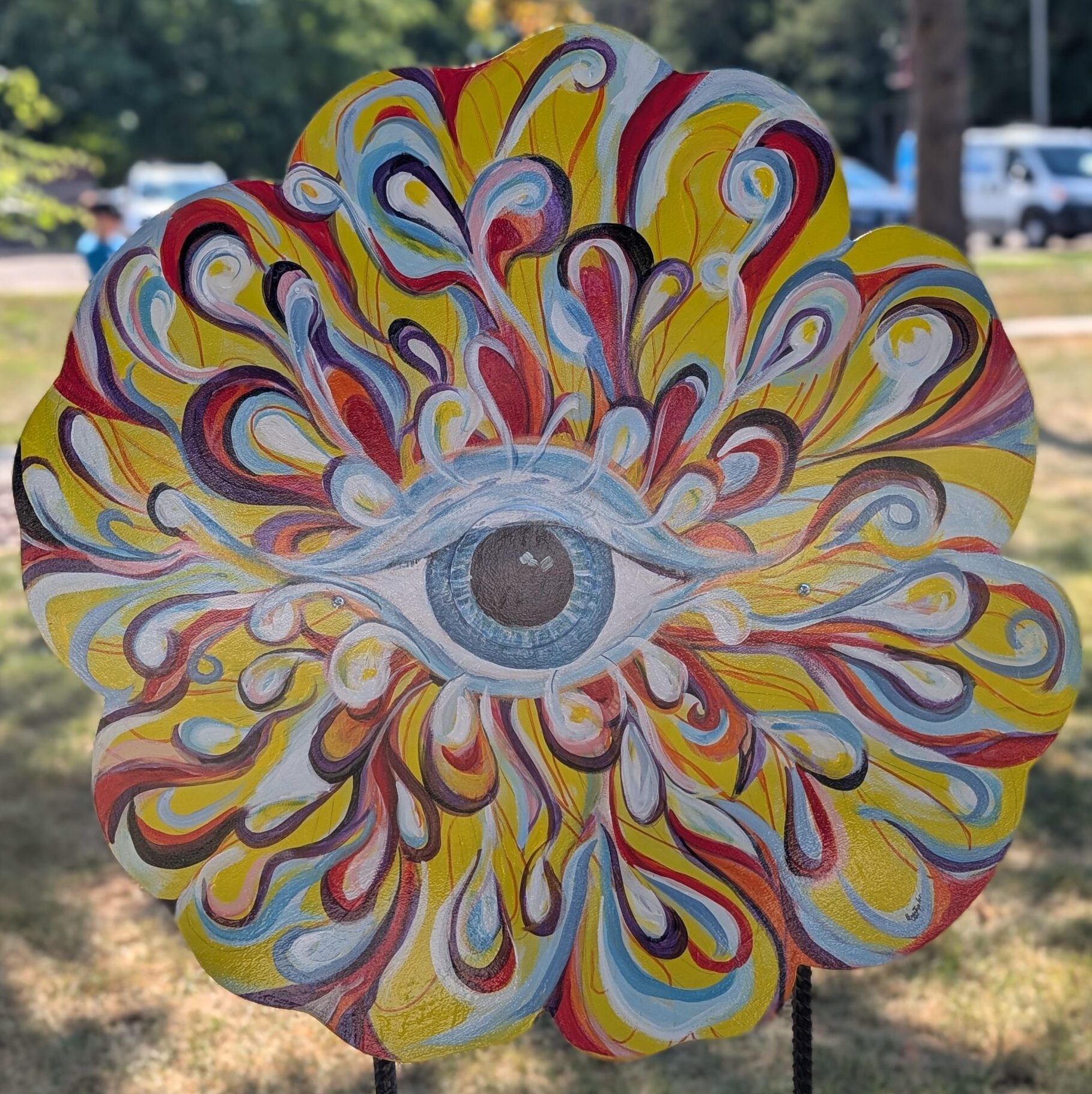 poppy cut-out painted with swirling colors and an eye in the middle
